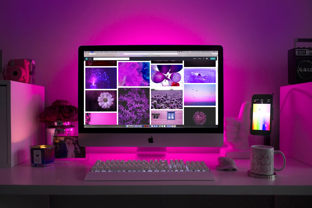 contact-img Modern desk setup with neon lighting and a desktop computer displaying colorful images.